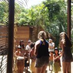 Rejsende og junglebeboere deltager sammen i en traditionel rituel dans i en lokal landsby.